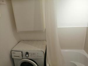 een kleine badkamer met een wasmachine en een douche bij Parkowy Apartment in Bydgoszcz
