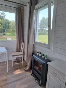 um quarto com um fogão, uma cadeira e uma janela em Sternenhof Wingst em Wingst