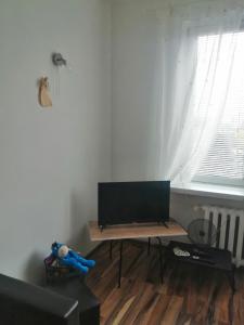 una sala de estar con mesa y TV. en Parkowy Apartment, en Bydgoszcz