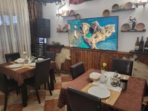 a dining room with two tables and a painting on the wall at VILA VALENCIA in Azuga