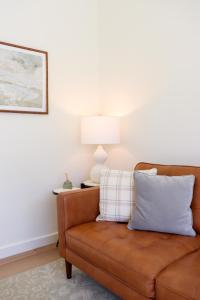 a brown leather couch in a living room with a lamp at Lobster Trap Tempe home in Tempe