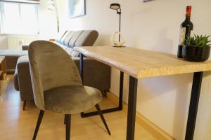einen Tisch mit einem Stuhl und eine Flasche Wein in der Unterkunft 3-Raum City-Appartement Jena in Jena