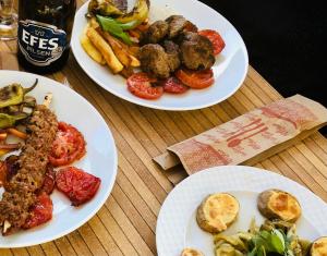 three plates of food on a wooden table at Karaca Apart Hotel in Dalyan