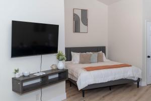 Modern Studio Type Apt close to Botanical Gardens في هانتسفيل: غرفة نوم مع تلفزيون بشاشة مسطحة كبيرة على الحائط