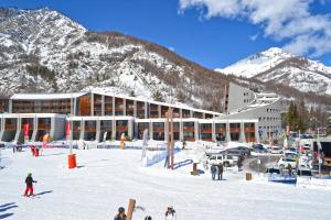 a group of people in the snow in front of a building at Appartamento Smith Roero - Affitti Brevi Italia in Bardonecchia