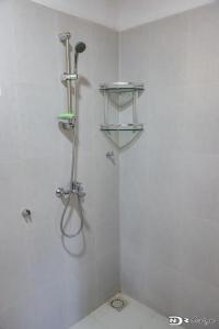 a shower in a white bathroom with a shower at Maison « tsarajoro »3ch majunga in Mahajanga