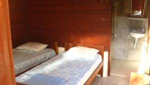 アイワルクにあるAyvalik Dostlar Pansiyonのベッド2台、シンクが備わる小さな部屋です。