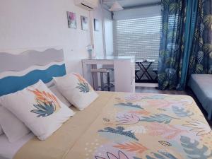 a bedroom with a bed with pillows and a table at Studio entre ciel et mer sans coupure d'eau in Le Gosier +33 photos