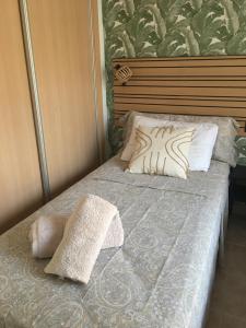 łóżko z dwiema poduszkami na górze w obiekcie Superbe appartement avec piscine à 800m de la mer w mieście Bahia de Casares
