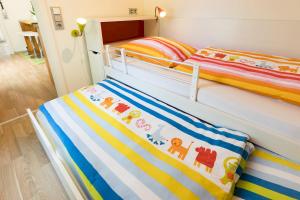 a bedroom with two bunk beds with colorful blankets at Ferienhaus Am Sedelbach in Deggenhausertal