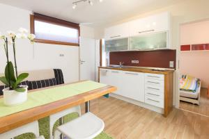 a kitchen with white cabinets and a table and chairs at Ferienhaus Am Sedelbach in Deggenhausertal +18 photos