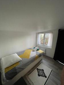 1 dormitorio con cama y ventana en Au logis du circuit des 24h00 en Le Mans