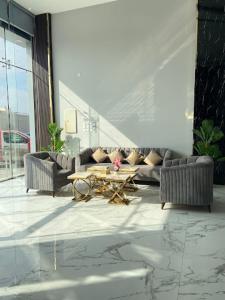un soggiorno con divani e tavolo in un edificio di فيو بارك للشقق الفندقية a Al Hofuf
