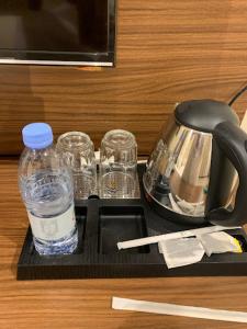 un vassoio con una bottiglia d'acqua e 2 bicchieri di فيو بارك للشقق الفندقية a Al Hofuf