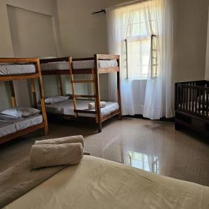 Mukamba Holiday House في ليفينغستون: غرفة بها ثلاثة أسرة بطابقين ونافذة