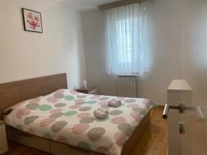 um quarto com uma cama com um cobertor de bolinhas em Affordable Apartments 8 em Zagreb