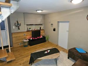 a living room with a couch and a television at Gîte Le pt'i Baillis in Nismes