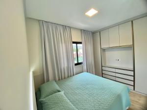 een kleine slaapkamer met een bed en een raam bij Bellacasa Rua Leão in Bombinhas