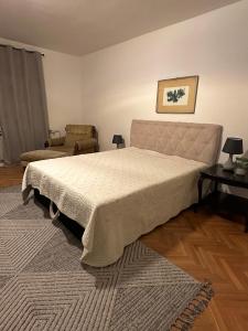 a bedroom with a large bed and a chair at Layla's Home Free Parking in Sarajevo