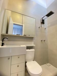 een badkamer met een toilet, een wastafel en een spiegel bij Bellacasa Rua Leão in Bombinhas +9 foto's