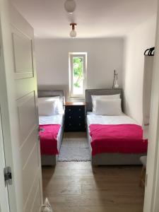 Duas camas num pequeno quarto com uma janela em Apartment Ana em Otok