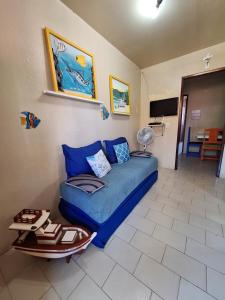 a living room with a blue couch and a table at Praia Flat in São José da Coroa Grande