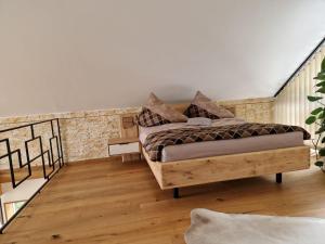 1 dormitorio con cama y pared de ladrillo en FERIENHAUS A&C DELUXE AM SEE en Spielberg