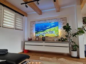 Televízia a/alebo spoločenská miestnosť v ubytovaní FERIENHAUS A&C DELUXE AM SEE