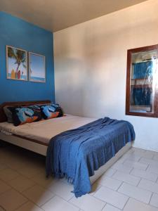 um quarto com uma cama com uma parede azul em Praia Flat em São José da Coroa Grande