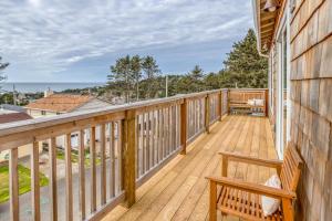 a wooden balcony with a bench on a house at Bannikov Beach House in Lincoln City