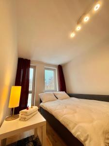 een slaapkamer met 2 bedden en een tafel met een lamp bij BEMA Guest House - City Centre in Wrocław