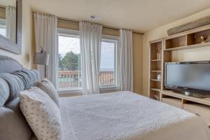 a bedroom with a bed and a flat screen tv at Bannikov Beach House in Lincoln City