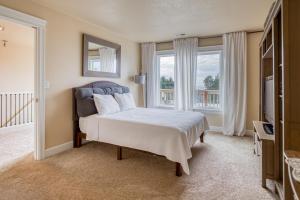a bedroom with a bed and a large window at Bannikov Beach House in Lincoln City