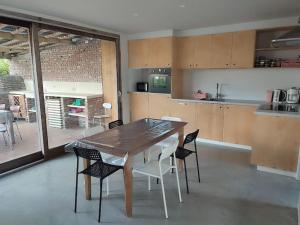 Huis Belijn في لوكيرين: مطبخ مع طاولة وكراسي خشبية