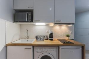 a kitchen with a sink and a washing machine at Rose, Appartement Confortable proche Metro in Montrouge +8 photos