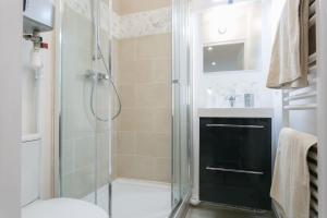 a bathroom with a shower with a glass shower backdoor at Rose, Appartement Confortable proche Metro in Montrouge