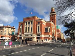 a building with a clock tower on top of it at Rose, Appartement Confortable proche Metro in Montrouge