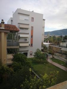um edifício de apartamentos branco com um quintal em frente em Athenian Luxury apartment, near metro station Chalandri, Nu 1 em Atenas