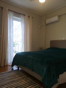 Un dormitorio con una cama verde y una ventana en Athenian Luxury apartment, near metro station Chalandri, Nu 1, en Atenas