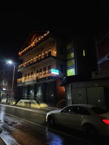 un coche aparcado delante de un edificio por la noche en Hostel Prishtina Backpackers, en Pristina