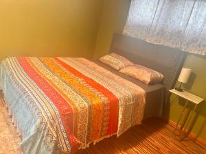 a bedroom with a bed with a colorful blanket at Cozy Apartments In Cheektowaga in Cheektowaga