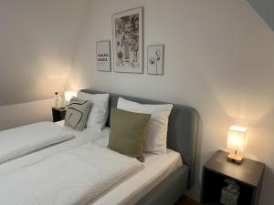 a white bedroom with two beds and a lamp at Phantasialand, Therme, Köln, Bonn, Arbeitsplatz, Bäckerei um die Ecke in Euskirchen