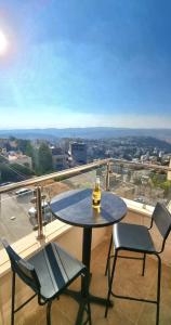 a table and two chairs on a balcony with a view at 3 Bedroom mountain view apartment overlooking Al Fuhais in Amman