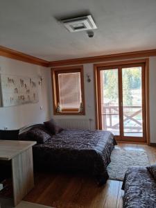 a bedroom with a bed and a couch and a window at Apartman 151 U u Aparthotelu Vučko Jahorina - private host in Jahorina