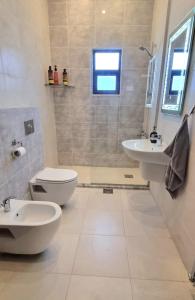 a bathroom with two sinks and a toilet and a shower at 3 Bedroom mountain view apartment overlooking Al Fuhais in Amman
