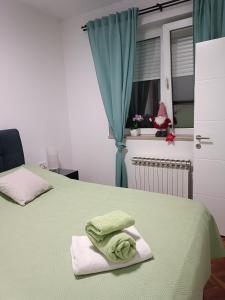 sypialnia z 2 łóżkami i zielonymi ręcznikami w obiekcie Apartman na jezeru w Zagrzebiu