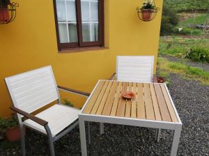 PuntallanaにあるCasa La Rehoyaの白い椅子2脚、木製テーブル(ドーナツ付)
