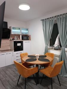 a kitchen and dining room with a table and chairs at Apartman na jezeru in Zagreb