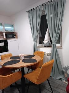 a table and chairs in a kitchen with a window at Apartman na jezeru in Zagreb
