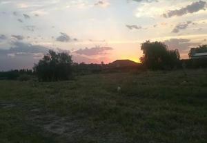 un campo con la puesta de sol en el horizonte en Bunker en San Rafael